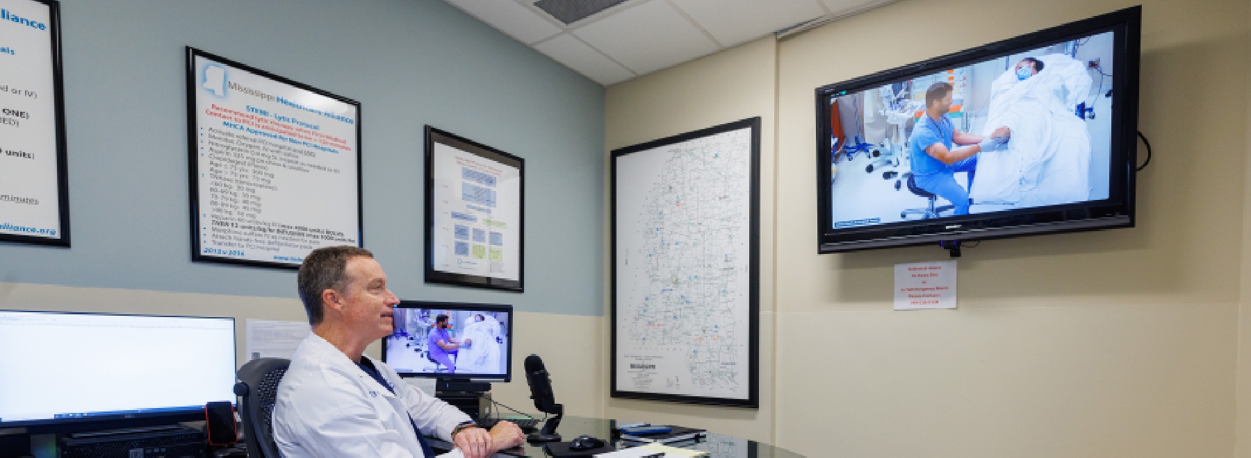 Photo of an off-site emergency room physician collaborating with an on-site ER doctor via telehealth technology